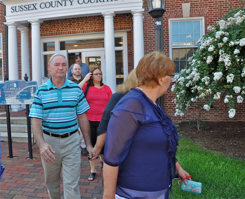 The family of accused murderer Matthew N. Burton files out of Superior Court in Georgetown Aug. 16. Superior Court Judge T. Henley Graves ruled Burton be extradited to Maryland to stand trial. At left is Burton's father, Gene Burton, holding hands with Burton's mother, Bonnie Burton. In back is Traci Burton, wife of Matthew Burton. BY RON MACARTHUR